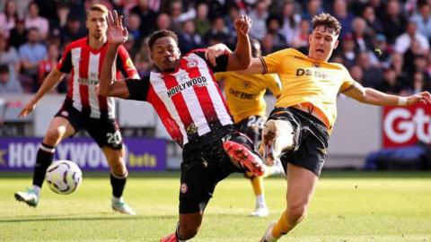 Jorgen Strand Larsen beats Ethan Pinnock to the ball in Wolverhampton Wanderers' Premier League match at Brentford