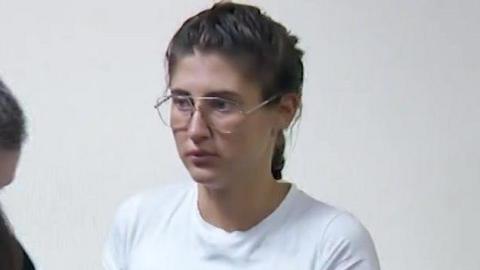Bella Culley filmed in court. She is wearing glasses and has brown hair in a plait and is wearing a white top