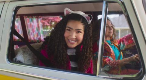Gabby smiles from window of Carlita, her campervan 