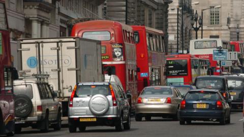 Congestion on the streets of central London, with cars and red buses in a traffic jam