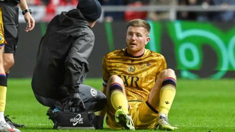 Scott Wharton sits on the turf next to the physio during Blackburn's win at Bristol City