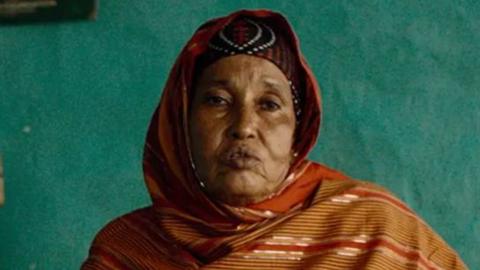 Woman with her head covered with a brown scarf