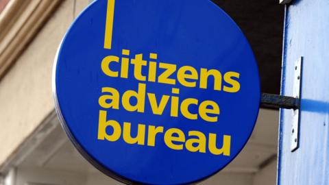 A round Citizens Advice Bureau sign. It is blue with yellow text.