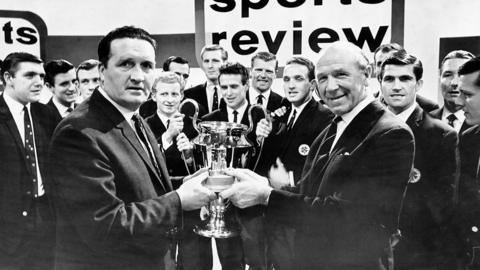 Manchester United football manager Matt Busby (right) handing the Team of the Year Trophy to Celtic manager Jock Stein (left), 1967.