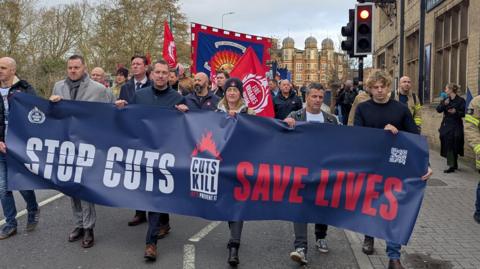 FBU members holding a banner whilst marching through Oxford.