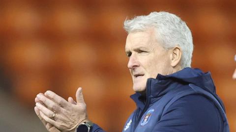 Mark Hughes claps the Carlisle fans after the FA Cup loss at Blackpool (with orange seats visible behind him) 