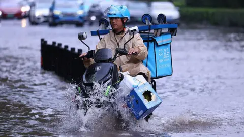 A man cycling through a flood