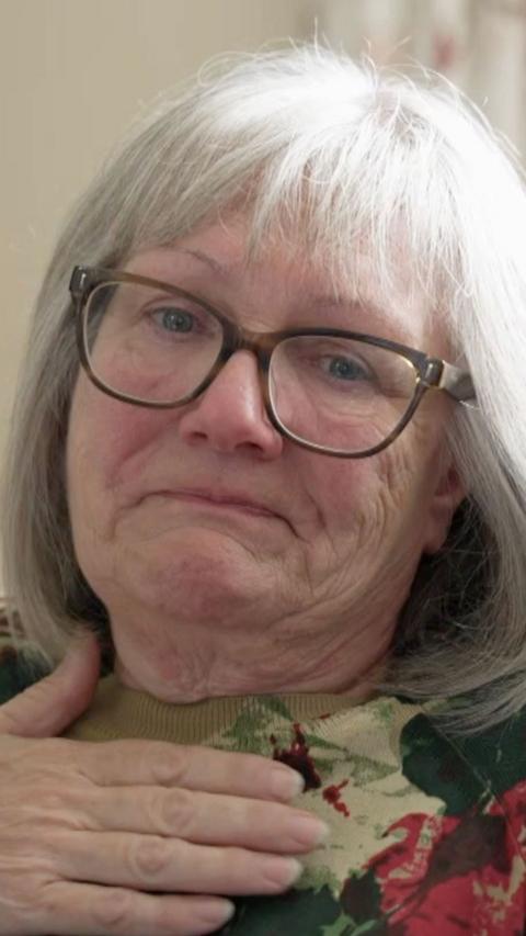 An elderly woman with white hair crying.