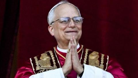 Pope Francis with his hands in a preying gesture as he appears for the first time after his election as pontiff