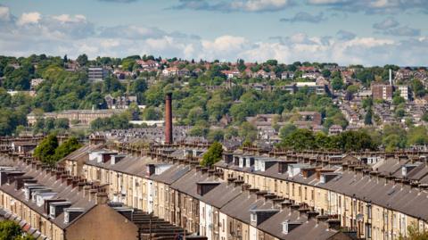 Bradford urban and suburban housing. Showing the stone terraced of the city houses and distant suburban areas.