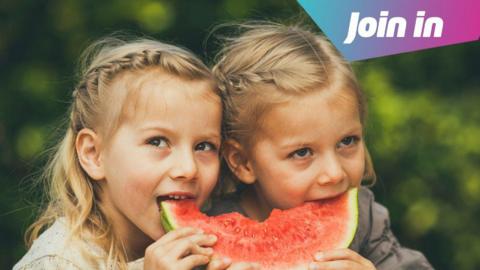 Twin girls eating a watermelon 