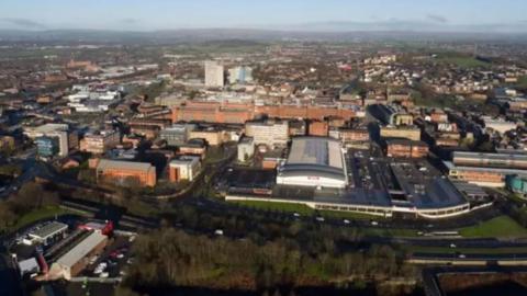 An aerial view of Oldham, with a range of buildings and roads seen from above