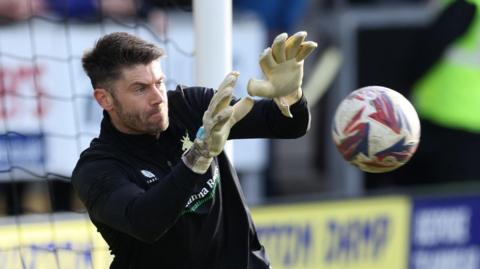 Scott Flinder makes a save while warming up for Mansfield Town