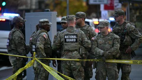 National Guard soldiers gather near a crime scene after a shooting in downtown Washington, DC.