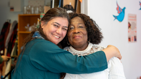 Two volunteers hug each other inside the current Aidbox premises. 