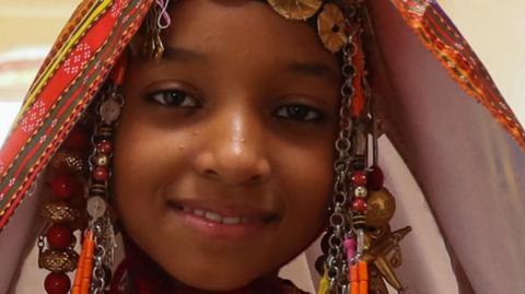 A girl dresses up for a festival in Libya