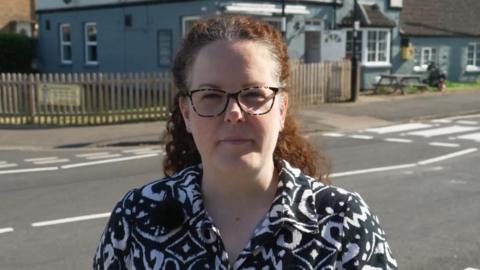 Werrington Primary School mother Kerri Deboo standing near the road outside the school which used to have a school crossing patrol person working