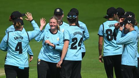 Surrey players congratulate Ryana McDonald-Gay (centre) in an earlier match this summer  