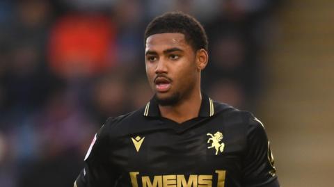 Travis Akomeah running on the pitch during a game for Gillingham