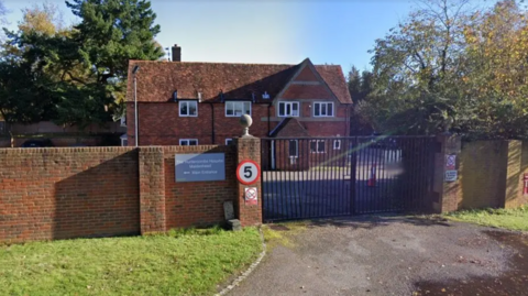 The hospital, which was a two-storey building, behind a black gate.