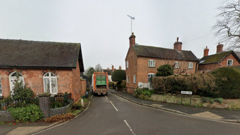 A general view of Trent Lane in the Derbyshire village of Newton Solney, from Main Street, showing a street sign which reads 'Trent Lane' and a bin lorry in the road