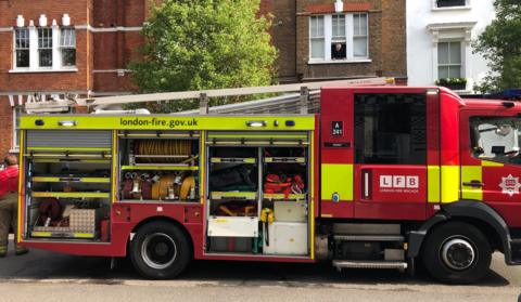 Red and yellow fire engine with LFB logo and fire hose