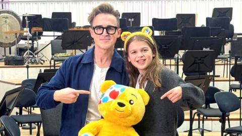 Tom Fletcher and his son Buzz holding a Pudsey bear.