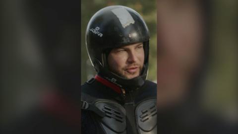 Chris Hughes wears black protective gear including a helmet 