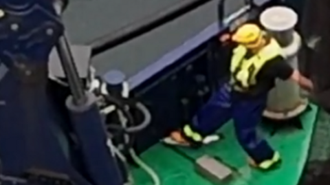 A grab from the footage which The Green Britain Foundation alleges shows a fish farm worker in the process of dumping a diseased fish into the sea.
