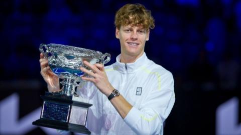 Jannik Sinner holds up the Australian Open trophy