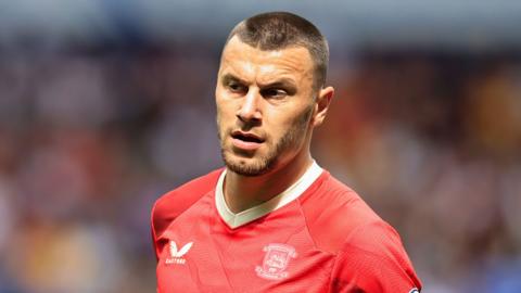 Milutin Osmajic playing for Preston away to Bolton, wearing North End's red away kit  