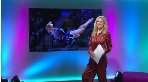 Jenny in the studio with a gymnast in the screen