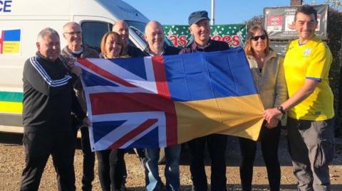 Volunteers holding the UK and Ukraine flags 