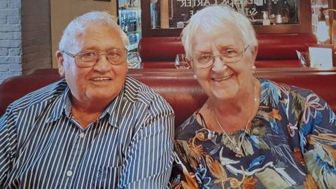 Llun o Marlene a William John Mumford yn gwenu. Cafodd y llun ei dynnu gan y teulu pan oedd y ddau allan yn mwynhau.