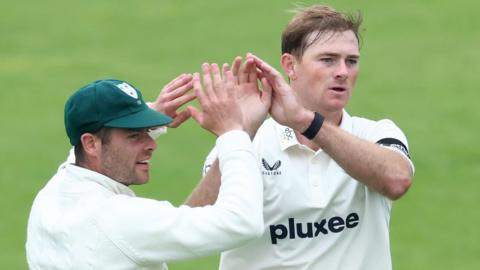 Tom Taylor celebrates a wicket with a Worcestershire team-mate