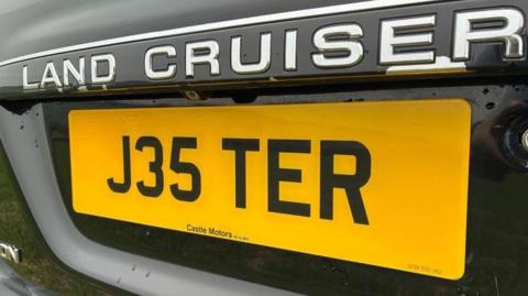 Yellow car number plate reading  'J35 TER' 