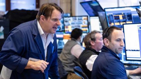 Traders work on the floor of the New York Stock Exchange in New York on 3 April 2025