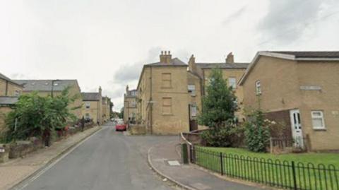 A residential street with clay-coloured houses.