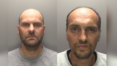 Man with beard and grey top and a man with beard and white top with a dark top underneath.
