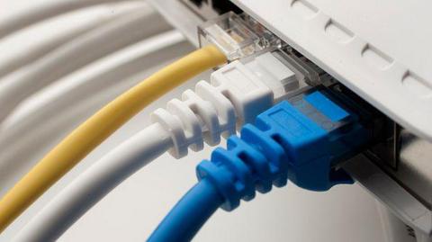 Part of a broadband box, with three coloured wires plugged into it.