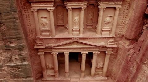 Image of an elaborate building with pillar carved out of a rock face - The Urn Tombs of Petra