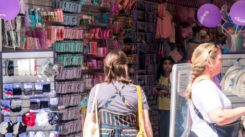 Shoppers inside a Claire's store with rows of merchandise