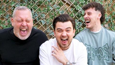Three men laughing together.