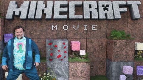 Jack Black stood in front of a Minecraft Movie backdrop 