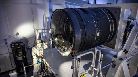 LSST Camera Deputy Project Manager Travis Lange shines a flashlight into the LSST Camera.