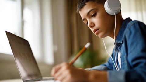 Boy sitting at computer with headphones on