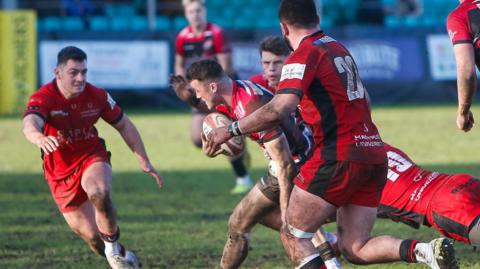 Cornish Pirates player running through Hartpury players