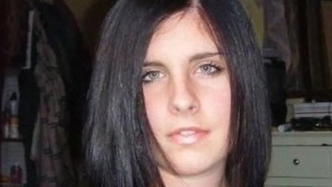 Close up of Sian's face. She has long brown hair and blue eyes. She is stood in a bedroom, with clothes and drawers behind her.