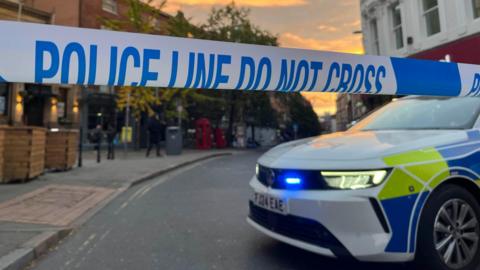 A police car parked next to police tape in Nottingham city centre