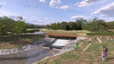 A computer generated picture showing a new spillway and bridge built across the Lower Cannop reservoir in the Forest of Dean. The site is surrounded by trees and a number of people are stood on the bank to the side of the water